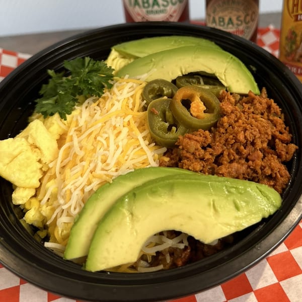 Tin Hut BBQ breakfast bowl with scrambled eggs, cheese, chorizo, jalapeños, and avocado slices.